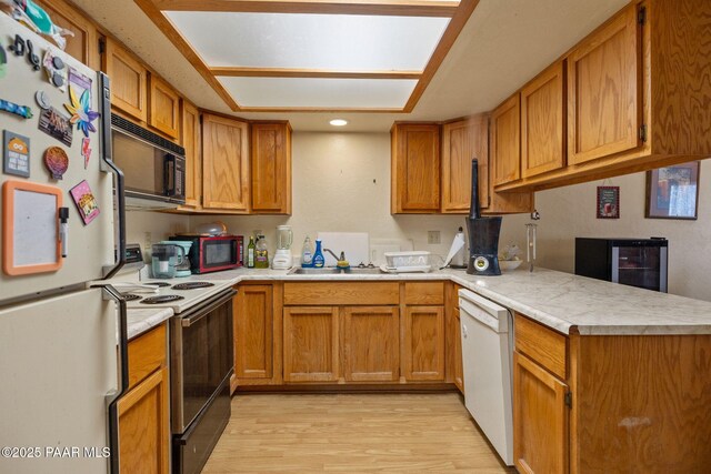 217 Creekside Cir Unit 16G, Prescott, AZ 86303 - kitchen featuring white appliances, light countertops, light wood-type flooring, and brown cabinetry