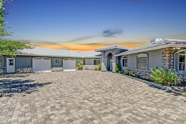 58 N French Pl, Prescott, AZ 86303 - prairie-style home with stucco siding, an attached garage, decorative driveway, and stone siding