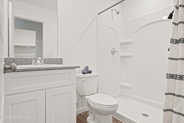 bathroom with toilet, walk in shower, vanity, and hardwood / wood-style flooring