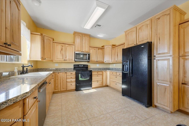 kitchen with stone counters, light brown cabinets, sink, light tile patterned floors, and black appliances