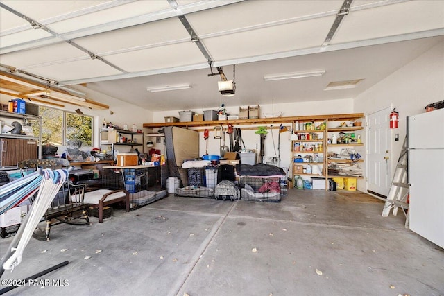 garage featuring white refrigerator and a garage door opener