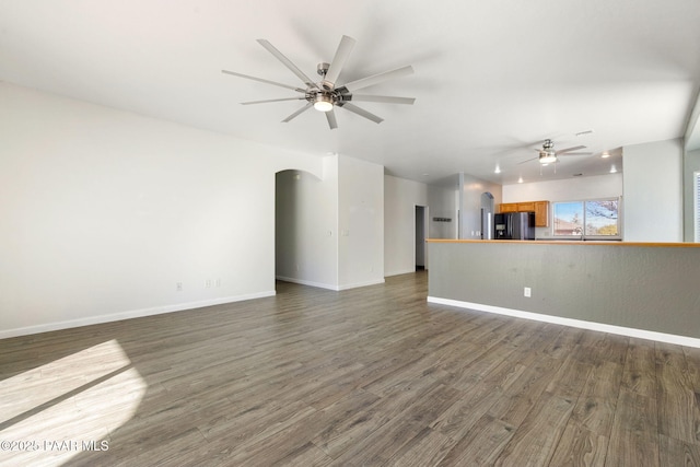 unfurnished living room with dark hardwood / wood-style floors and ceiling fan