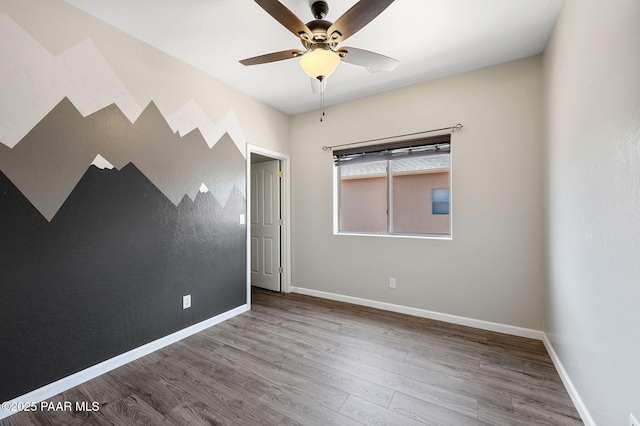 empty room with hardwood / wood-style flooring and ceiling fan