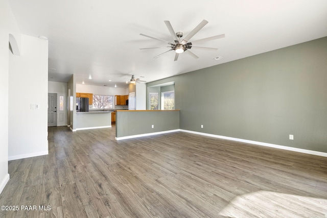 unfurnished living room featuring wood-type flooring and ceiling fan