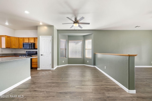 kitchen featuring dark wood-type flooring, ceiling fan, and range