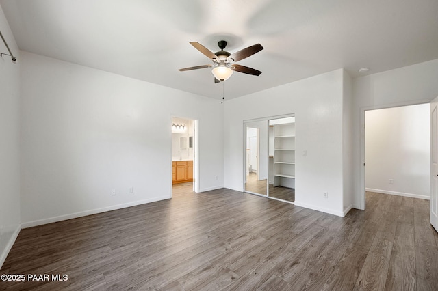 unfurnished bedroom with ensuite bathroom, hardwood / wood-style floors, ceiling fan, and a closet