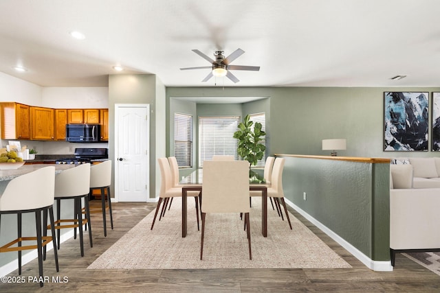 dining space featuring dark wood-type flooring and ceiling fan