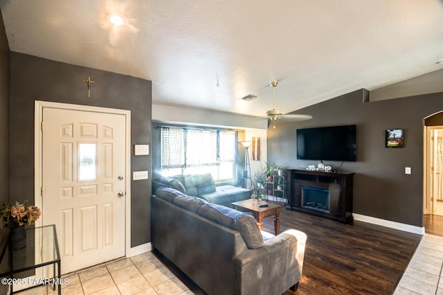 6126 N Little Papoose Dr, Prescott Valley, AZ 86314 - tiled living room with vaulted ceiling, a ceiling fan, and a fireplace