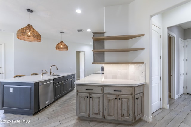 kitchen with light countertops, stainless steel dishwasher, wood tiled floor, and a sink