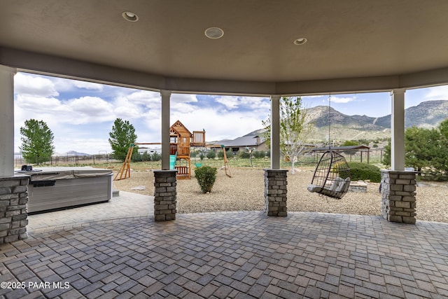 view of patio featuring area for grilling, a mountain view, a playground, and fence