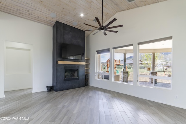 unfurnished living room featuring wood finished floors, high vaulted ceiling, wooden ceiling, a fireplace, and a ceiling fan