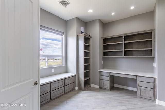 unfurnished office featuring light wood-type flooring, visible vents, baseboards, built in study area, and recessed lighting