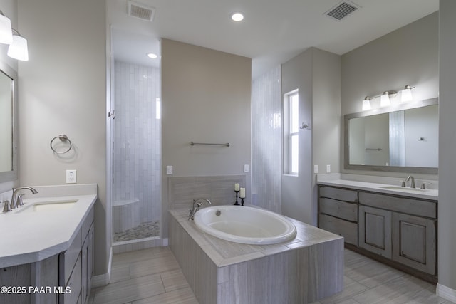 full bathroom featuring a sink, a garden tub, and visible vents