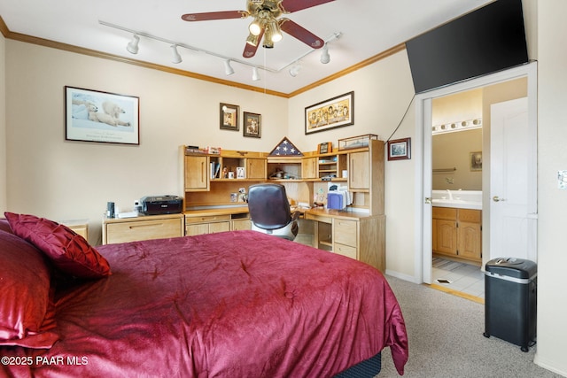 bedroom featuring baseboards, light colored carpet, ornamental molding, ensuite bathroom, and a sink