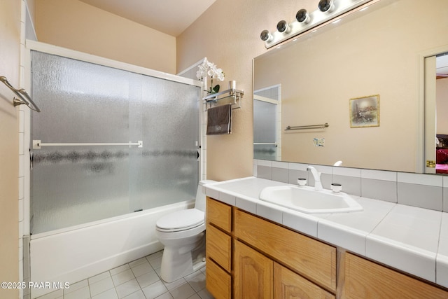 full bathroom featuring tile patterned flooring, toilet, vanity, and shower / bath combination with glass door
