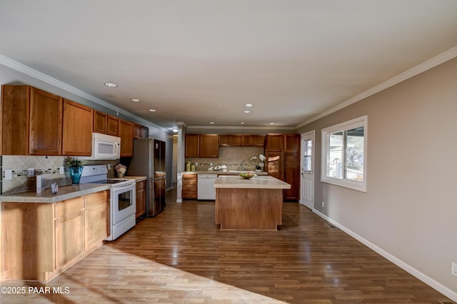 kitchen featuring hardwood / wood-style floors, white appliances, ornamental molding, and a kitchen island