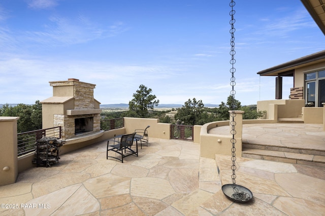 view of patio with an outdoor stone fireplace