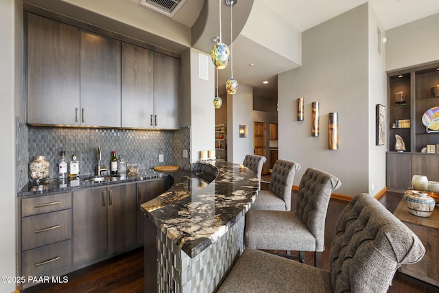 dining space with dark hardwood / wood-style floors and indoor wet bar