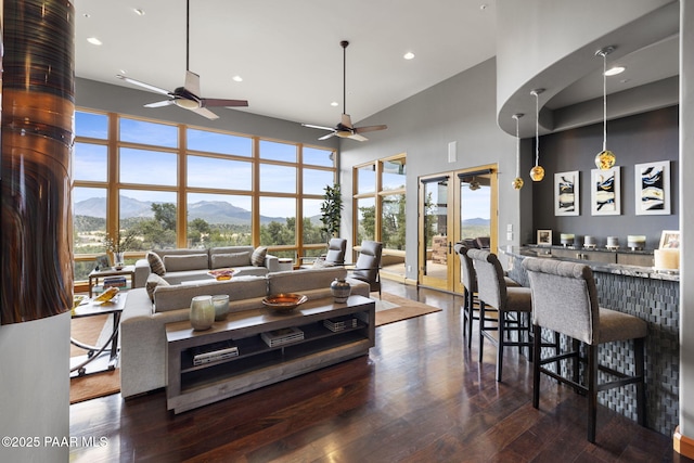 living room featuring dark wood-type flooring, a mountain view, and a high ceiling