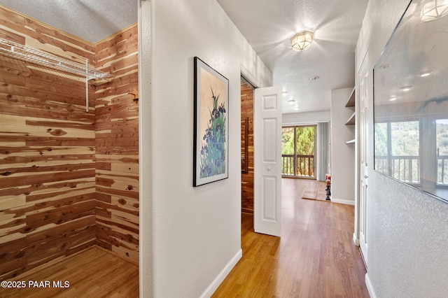 corridor with baseboards and wood finished floors