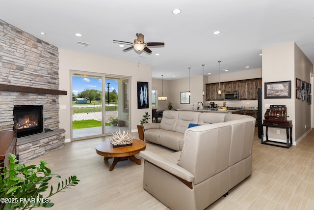 living room with a fireplace, baseboards, a ceiling fan, and recessed lighting