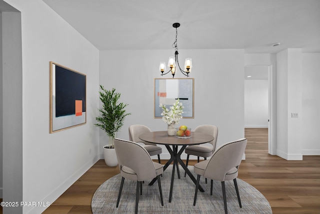 dining space featuring dark hardwood / wood-style floors and a chandelier