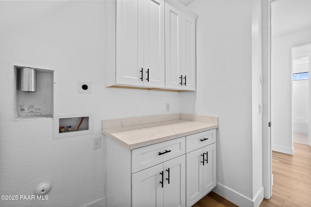 interior space featuring light stone countertops, white cabinetry, and light wood-type flooring