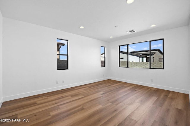 unfurnished room featuring a healthy amount of sunlight and hardwood / wood-style flooring