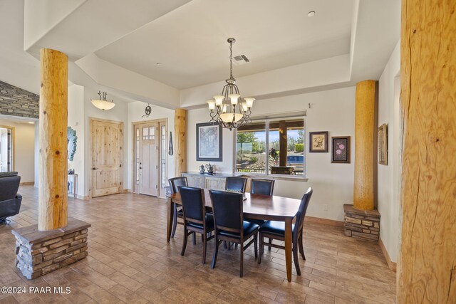 dining space with a raised ceiling and an inviting chandelier