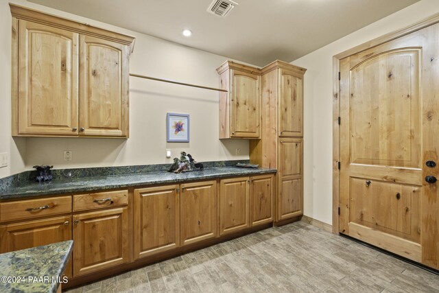 kitchen featuring dark stone counters and light hardwood / wood-style flooring