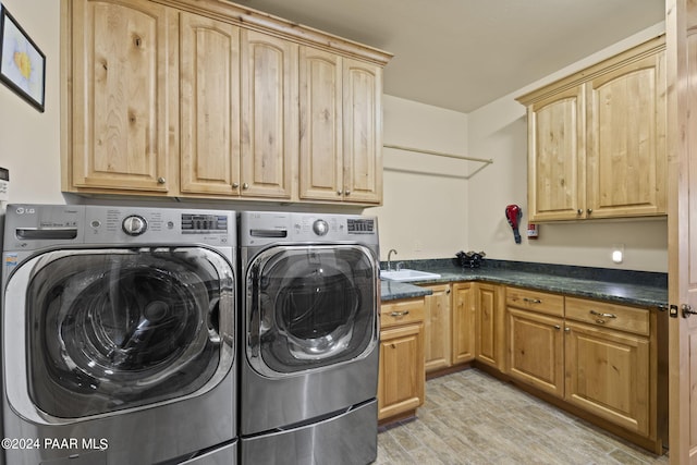 washroom featuring cabinets, light hardwood / wood-style floors, sink, and washer and dryer