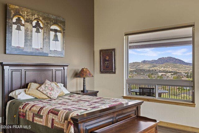 bedroom with wood-type flooring and a mountain view