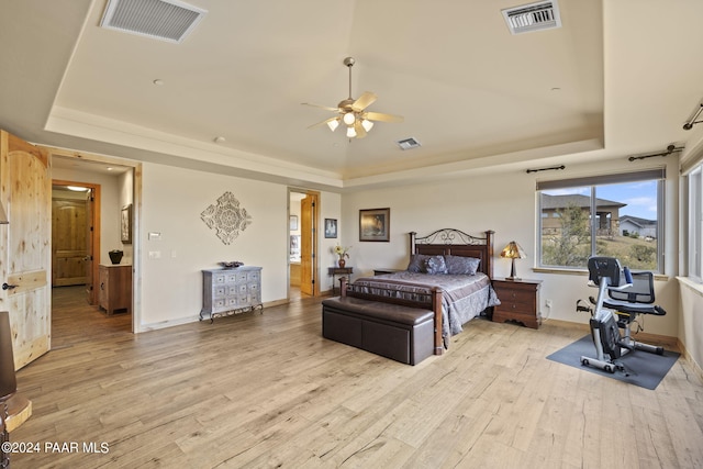 bedroom featuring light wood-type flooring and a tray ceiling