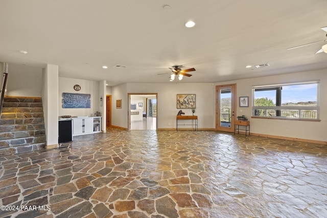 unfurnished living room with ceiling fan