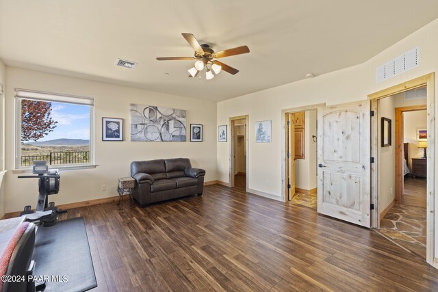 living room with dark wood-type flooring and ceiling fan