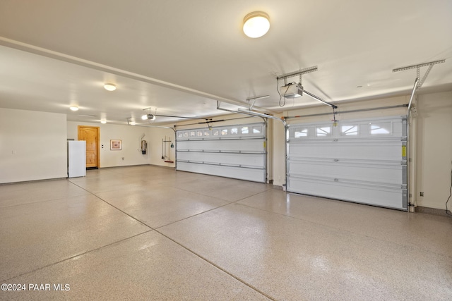 garage featuring a garage door opener and white fridge