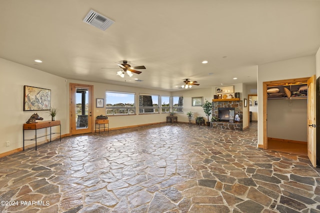 unfurnished living room with a fireplace and ceiling fan