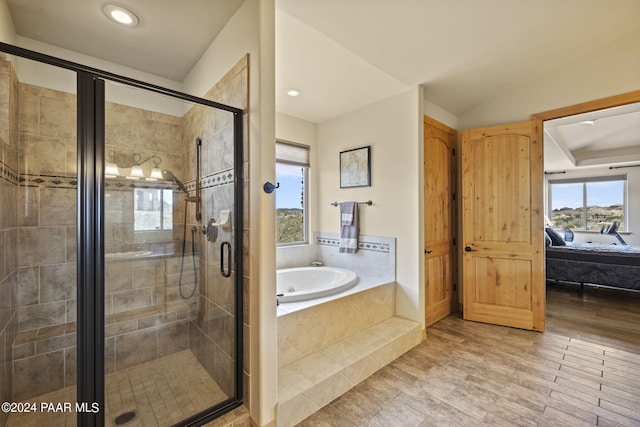 bathroom featuring lofted ceiling and independent shower and bath