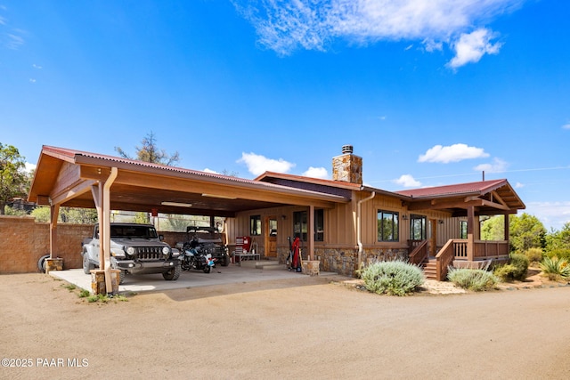 13225 N Bull Run Rd, Prescott, AZ 86305 - back of property featuring a chimney, board and batten siding, a carport, stone siding, and driveway