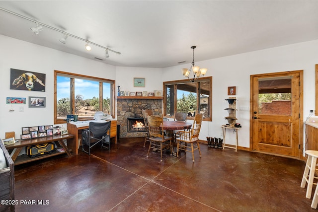 13225 N Bull Run Rd, Prescott, AZ 86305 - dining room featuring concrete flooring, a chandelier, a fireplace, and rail lighting