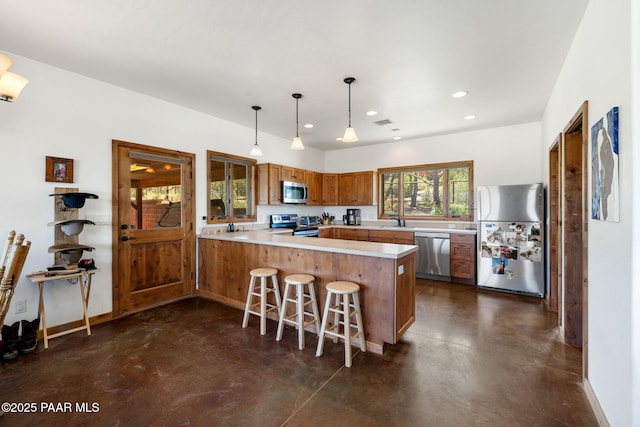 13225 N Bull Run Rd, Prescott, AZ 86305 - kitchen with appliances with stainless steel finishes, concrete floors, a peninsula, brown cabinets, and recessed lighting