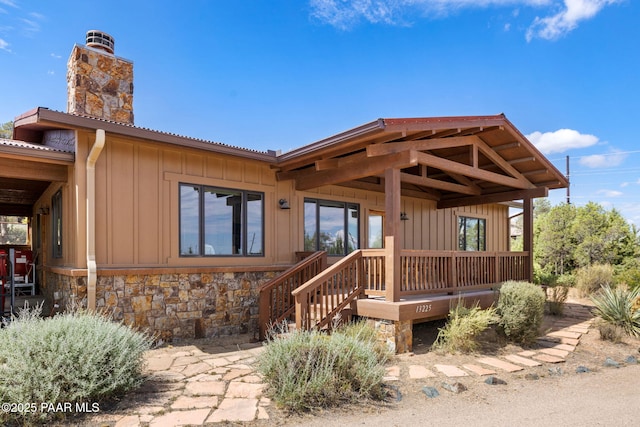 13225 N Bull Run Rd, Prescott, AZ 86305 - view of front of home with board and batten siding, a chimney, and stone siding