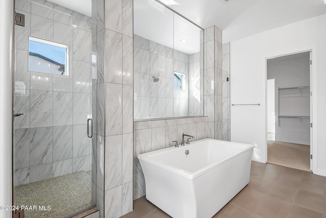 bathroom featuring tile patterned flooring, shower with separate bathtub, and tile walls