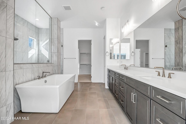 bathroom featuring tile patterned floors, vanity, tile walls, and shower with separate bathtub