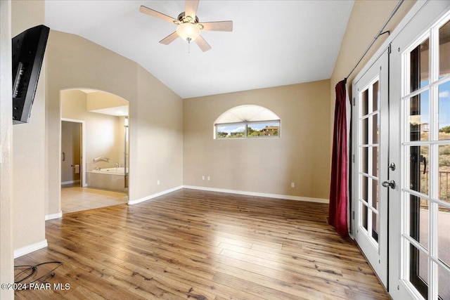 spare room featuring vaulted ceiling, ceiling fan, and light wood-type flooring