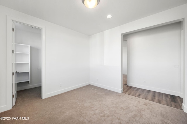 unfurnished bedroom with a walk in closet, carpet floors, and a closet