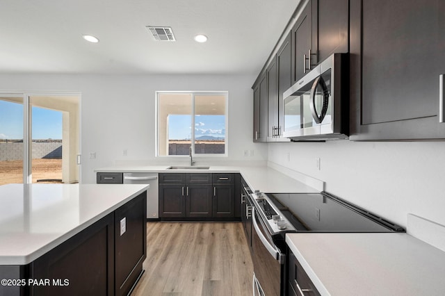 kitchen featuring plenty of natural light, sink, appliances with stainless steel finishes, and light hardwood / wood-style flooring