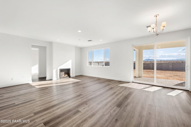 unfurnished living room featuring hardwood / wood-style floors and a chandelier