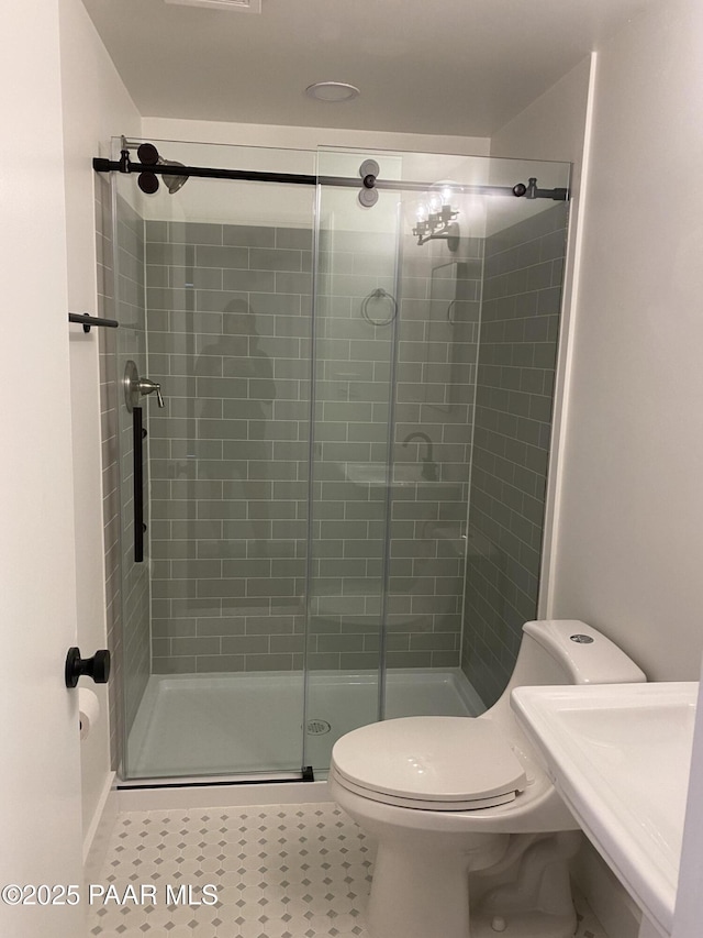 full bathroom with tile patterned flooring, a stall shower, and toilet
