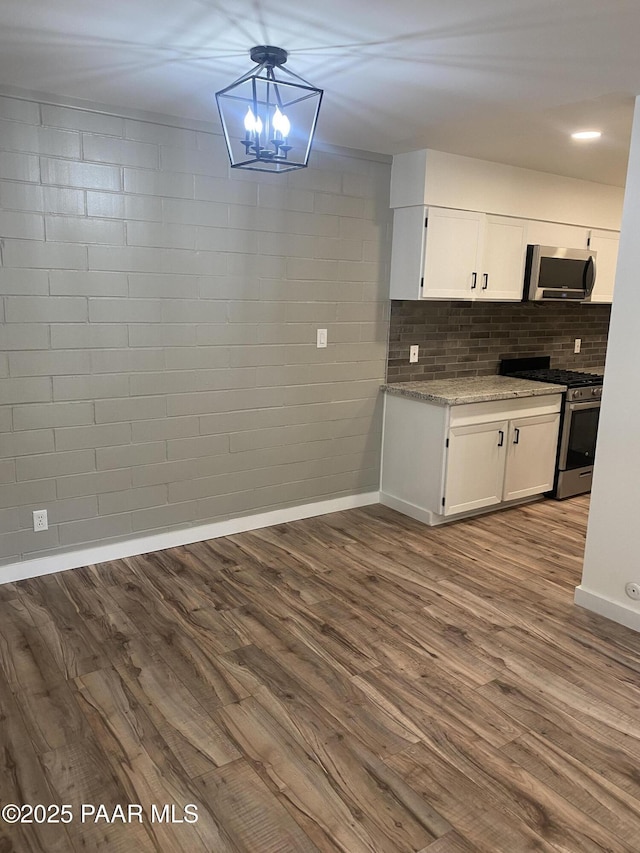 kitchen with white cabinets, stainless steel appliances, and dark wood-type flooring